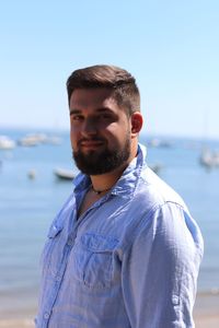 Portrait of smiling young man standing at beach