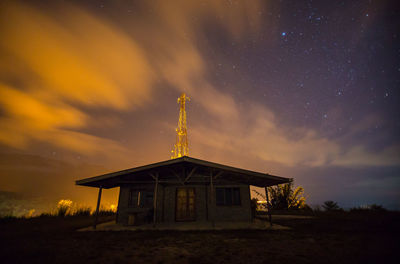 Low angle view of house on field against sky at night