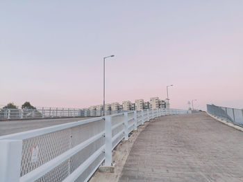 Bridge over street against sky during sunset