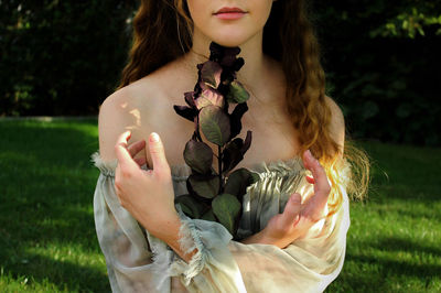 Woman with plant on grass