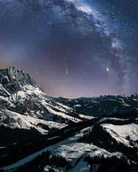 Scenic view of snowcapped mountains against sky at night