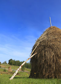 Hay bales on field against clear sky