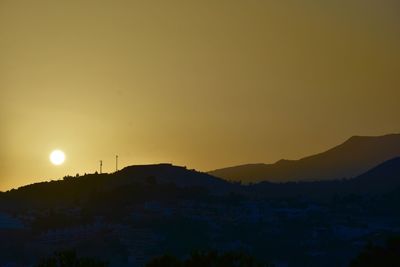 Scenic view of mountains against clear sky at sunset