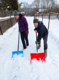 Senior man cleaning snow on street