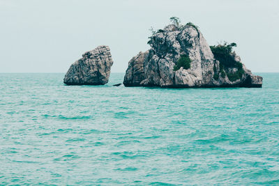 Scenic view of rock formation by sea against sky