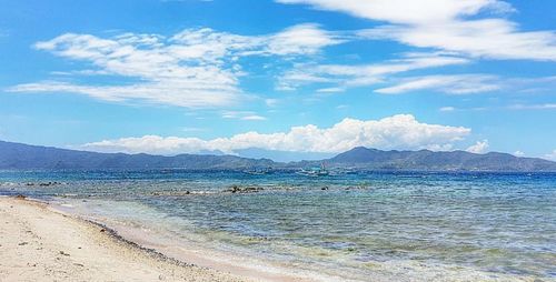 Scenic view of beach against blue sky