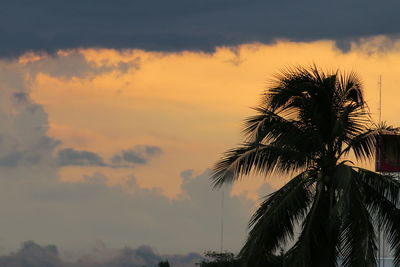 Silhouette palm trees against sky during sunset