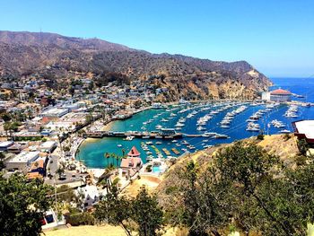 High angle view of townscape by sea against blue sky