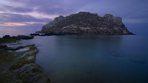 Rock formations in sea against sky