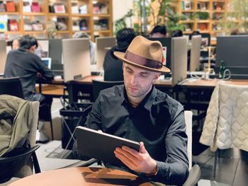 A man in a hat using laptop .  gentleman