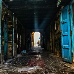 Rear view of woman in tunnel amidst buildings