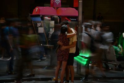 Woman standing in illuminated city at night