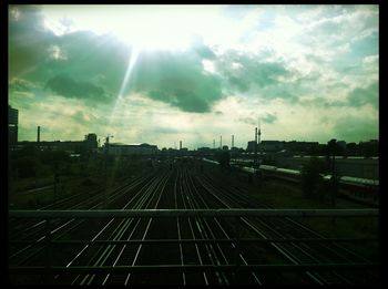 Railroad tracks against cloudy sky