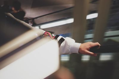 Close-up of hand holding railing on escalator