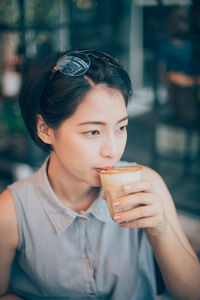 Close-up of young woman drinking drink in cafe