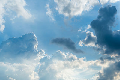 Low angle view of sunlight streaming through clouds