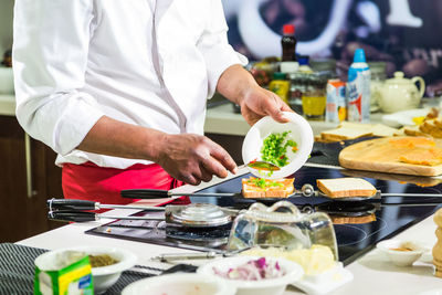 Midsection of man preparing food in restaurant