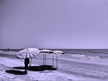 People on beach against clear sky