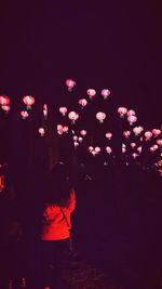 View of people with arms raised at night