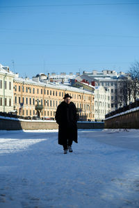 Rear view of woman standing in city during winter