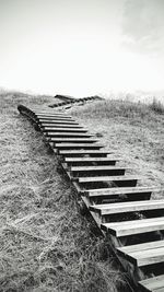 View of railroad tracks on field against sky