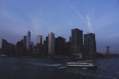 Modern buildings by sea against sky in city