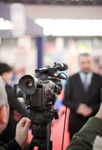 Man filming businessmen through video camera at event