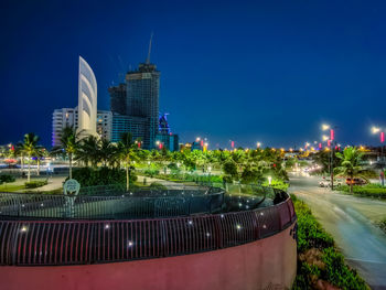 Illuminated city buildings against sky at night