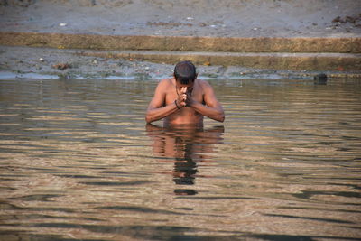 Full length of shirtless man in lake