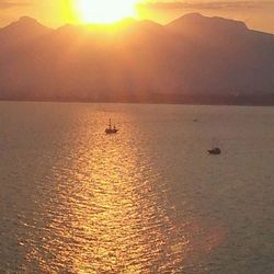 Boats in sea at sunset