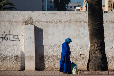 Side view of women against wall in building