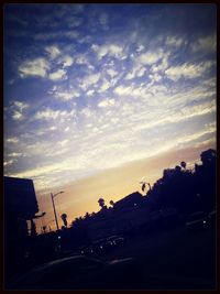 Cars on road against cloudy sky