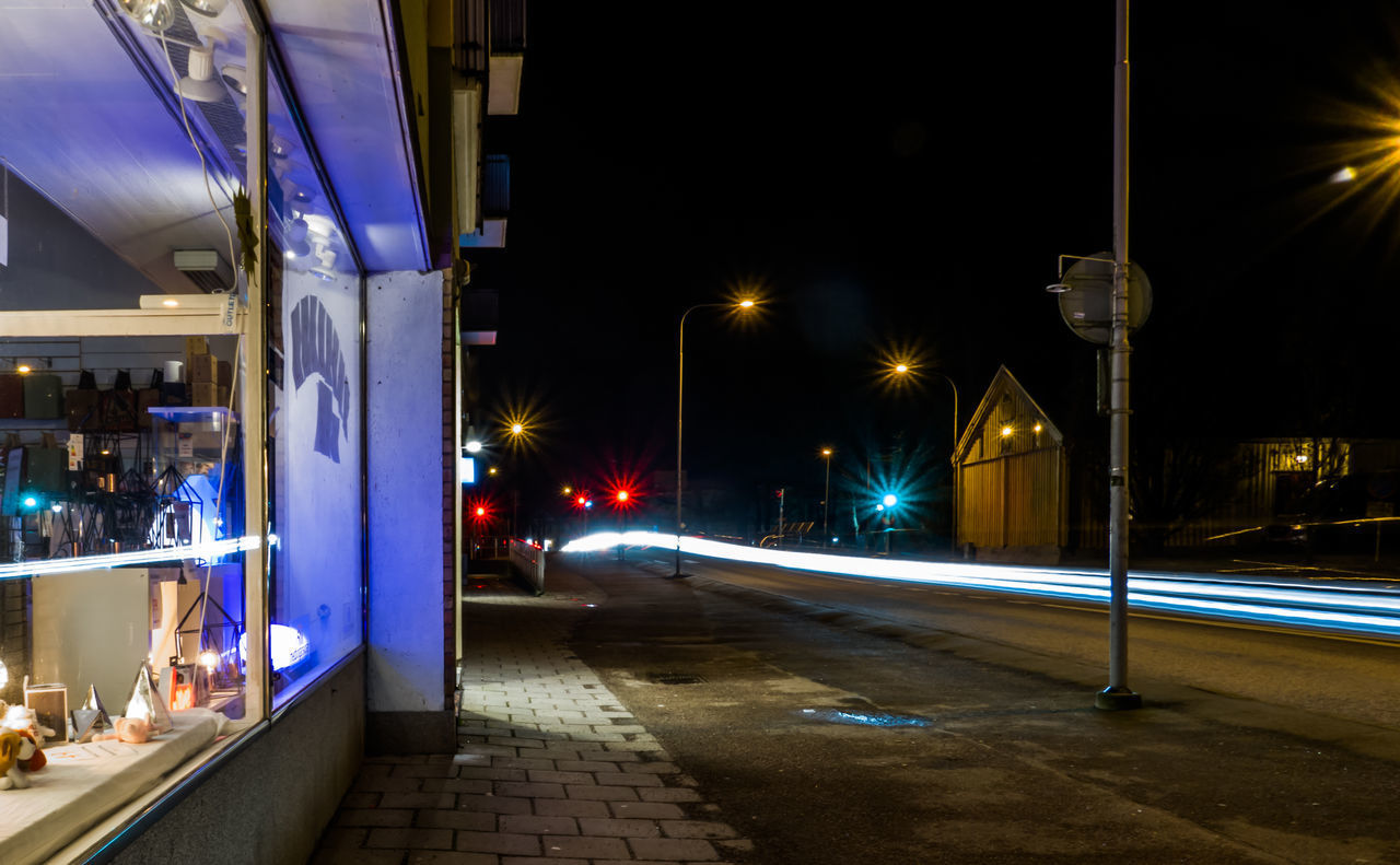 LIGHT TRAILS ON STREET AT NIGHT