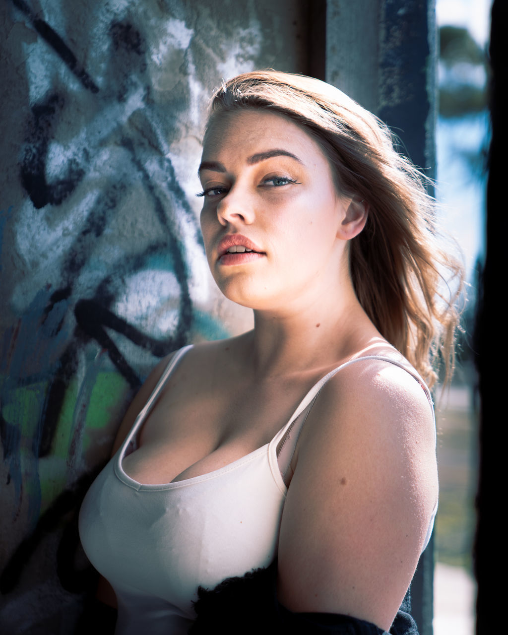 one person, women, adult, young adult, female, portrait, fashion, hairstyle, person, clothing, photo shoot, contemplation, looking, long hair, nature, lifestyles, outdoors, portrait photography, serious, graffiti, looking at camera, waist up, human face, emotion