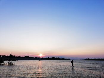 Scenic view of lake against clear sky during sunset