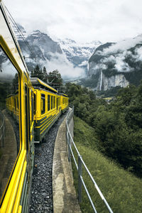 Train on railroad track by mountain
