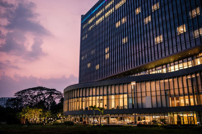 Low angle view of illuminated building against sky at sunset