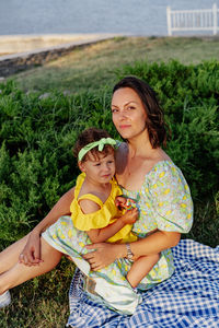 Portrait of smiling young woman sitting on field