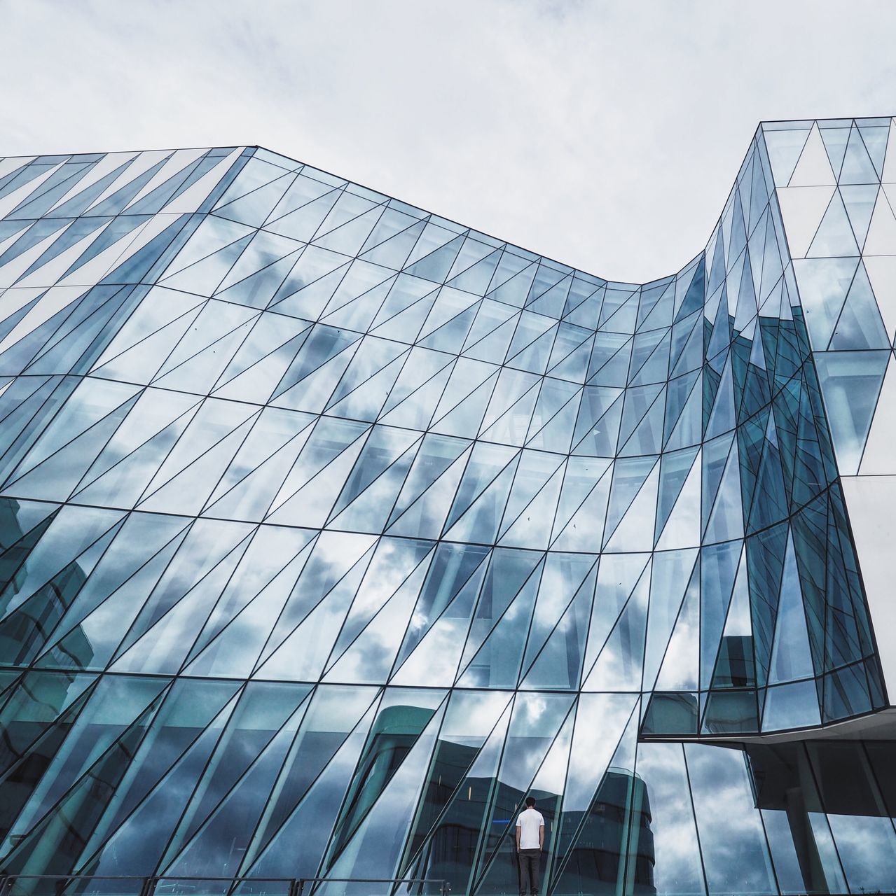 low angle view, architecture, built structure, building exterior, glass - material, modern, building, office building, sky, reflection, tall - high, skyscraper, tower, city, cloud, cloud - sky, day, outdoors, glass, tall, architectural feature, no people, city life, bright