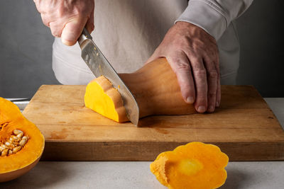Cropped hands of chef preparing food on cutting board