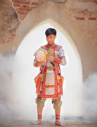 Full length of man wearing traditional clothing while standing against building