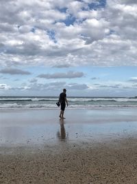 Man standing on beach against sky