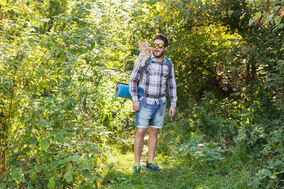 Full length portrait of man standing against trees