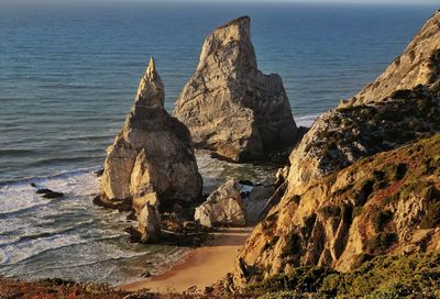 Rock formations by sea against sky