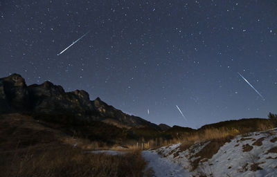 Scenic view of snowcapped mountains against sky at night