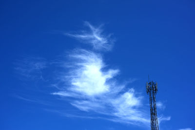 Low angle view of communications tower against blue sky