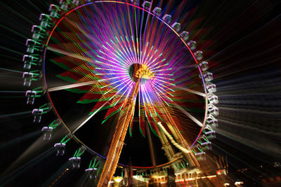 Low angle view of illuminated ferris wheel against sky at night