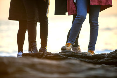 Low section of women standing on rock formations