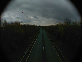 Road amidst trees against sky