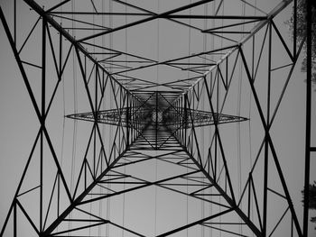 Low angle view of electricity pylon against clear sky